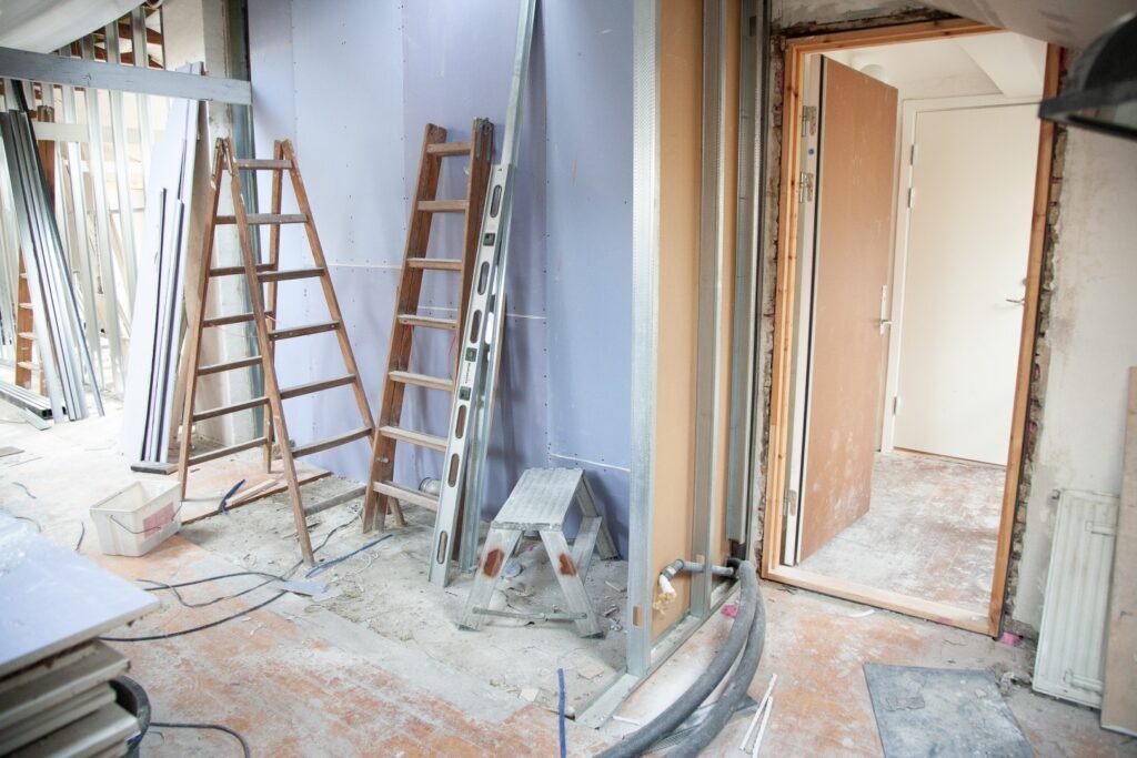 Room under renovation with exposed framing and ladders