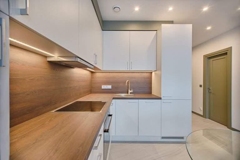 Compact kitchen with white cabinets and wood-effect worktops